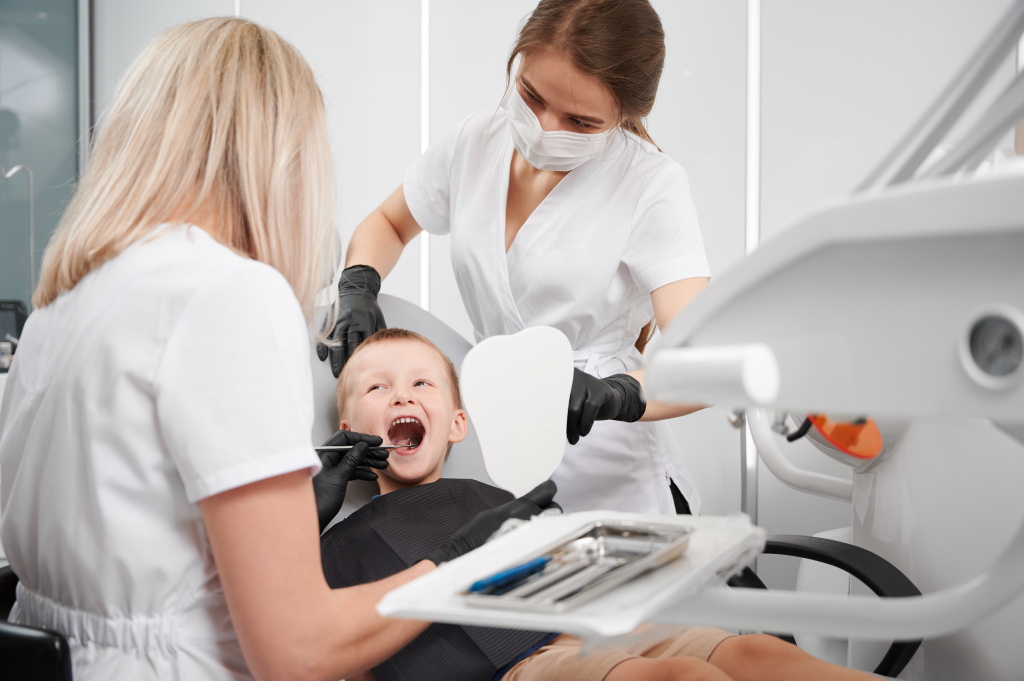 dentist-assistant-examining-child-teeth-dental-office.jpg