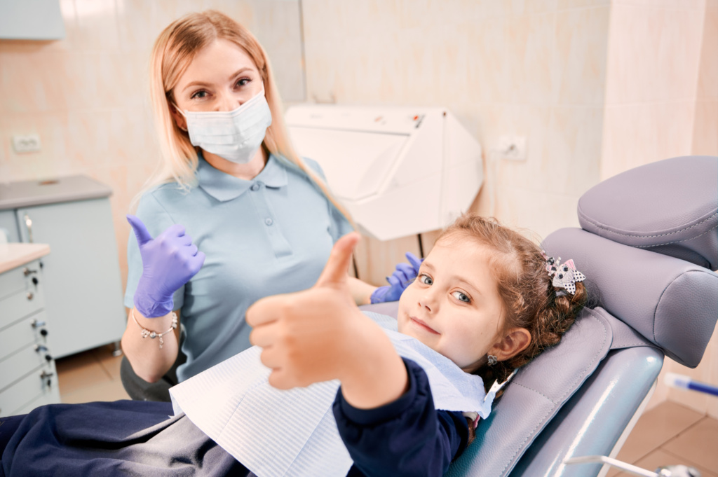 female-dentist-cute-little-girl-giving-thumbs-up.jpg
